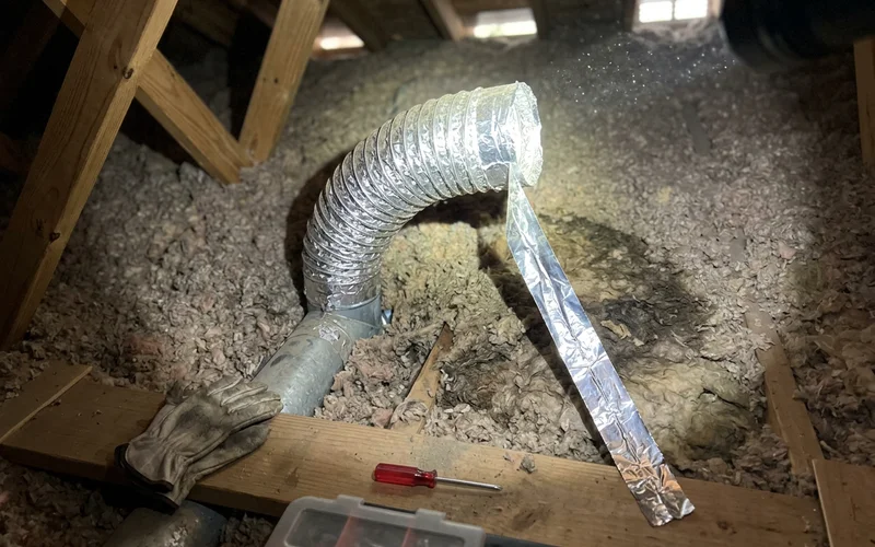 A bathroom exhaust duct venting into an attic instead of outside