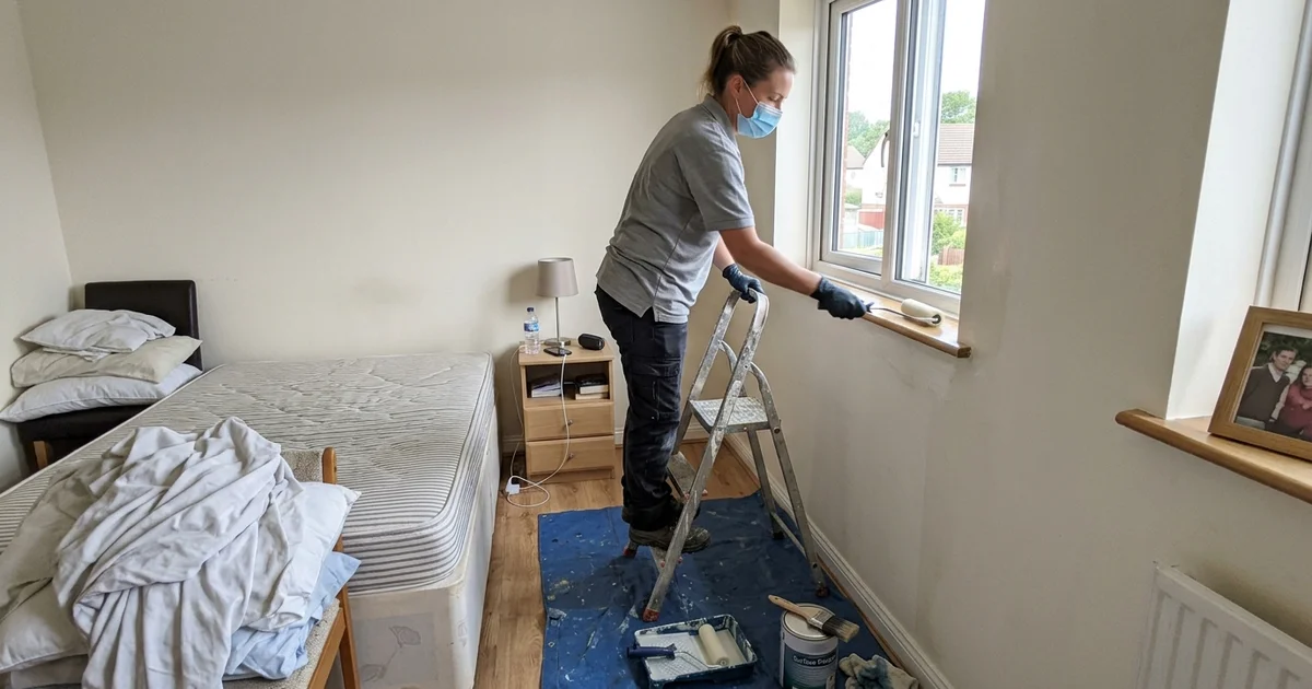 Technician applying an antimicrobial coating in a home bedroom