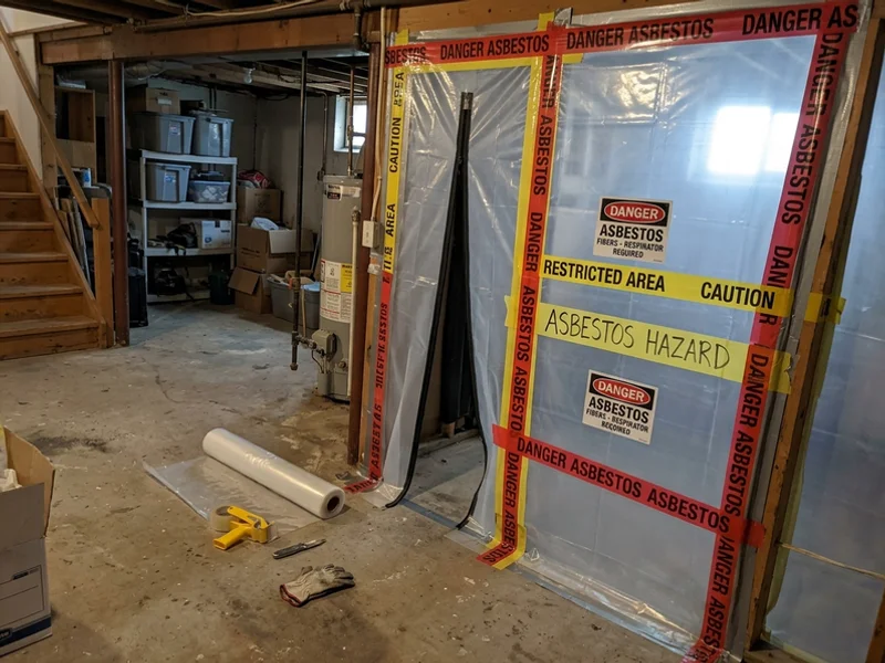 Sealed containment barrier with asbestos warning signage